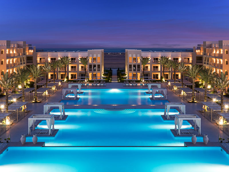 Beleuchtete Poolanlage und Hotelgebäude des Jaz Aquaviva am Abend